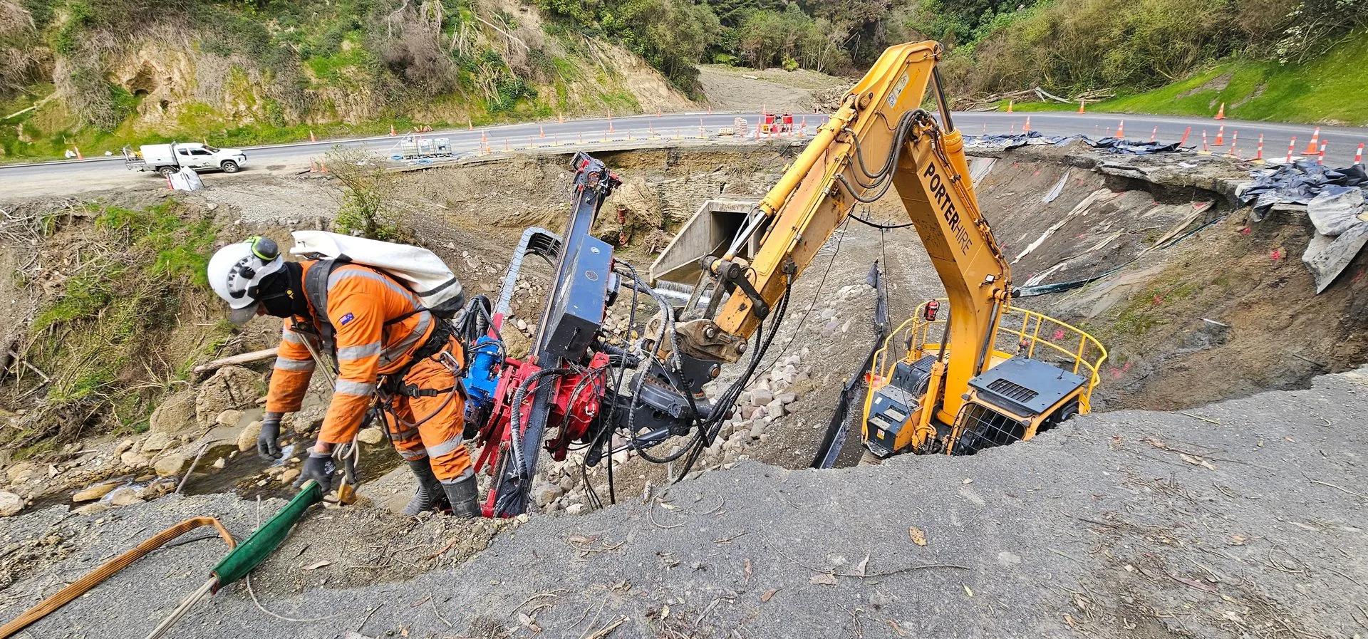 Aerial view of GSI excavator and crew responding to an active road failure in NZ native bush