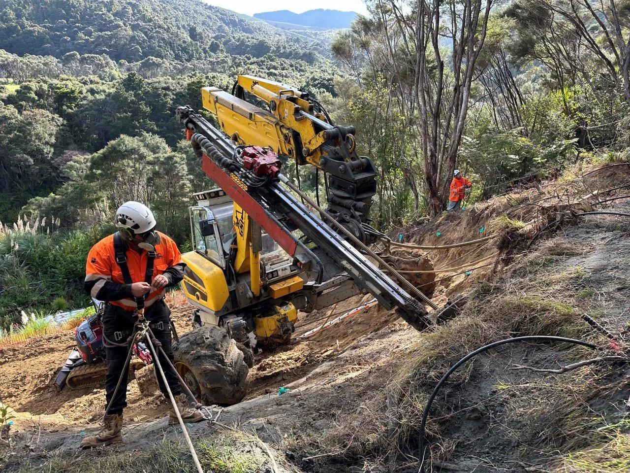 Aerial view of a NZ riparian bluff failure with rope access crew carrying out stabilisation works